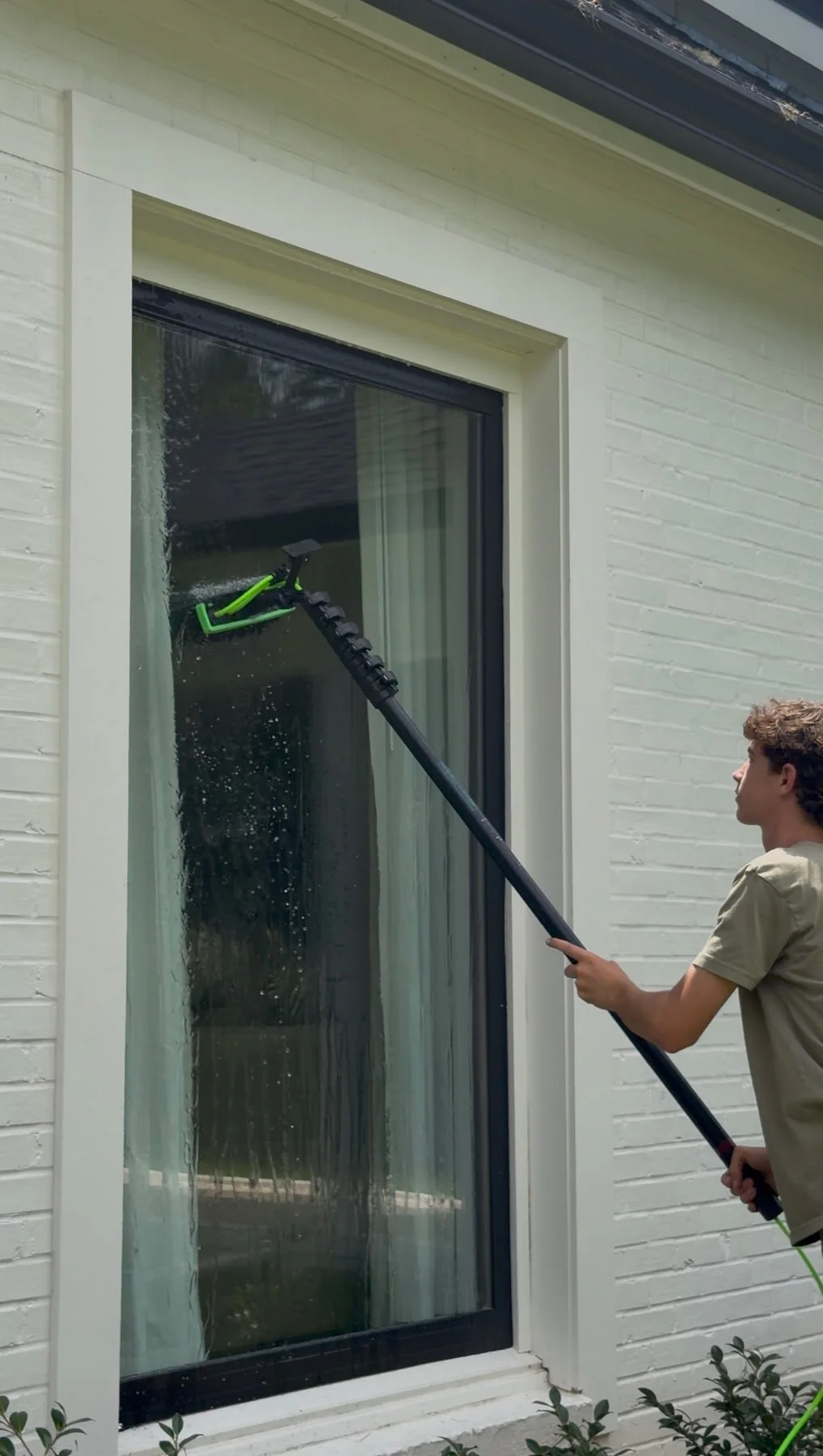 Brooks Safley cleaning an exterior window with an RODI water fed pole.